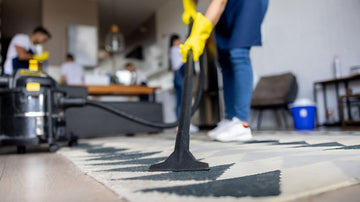 Upright canister stick robot and handheld vacuum cleaners displayed in a modern living room with mixed flooring